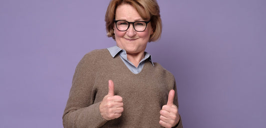 woman with glasses holding two thumbs up