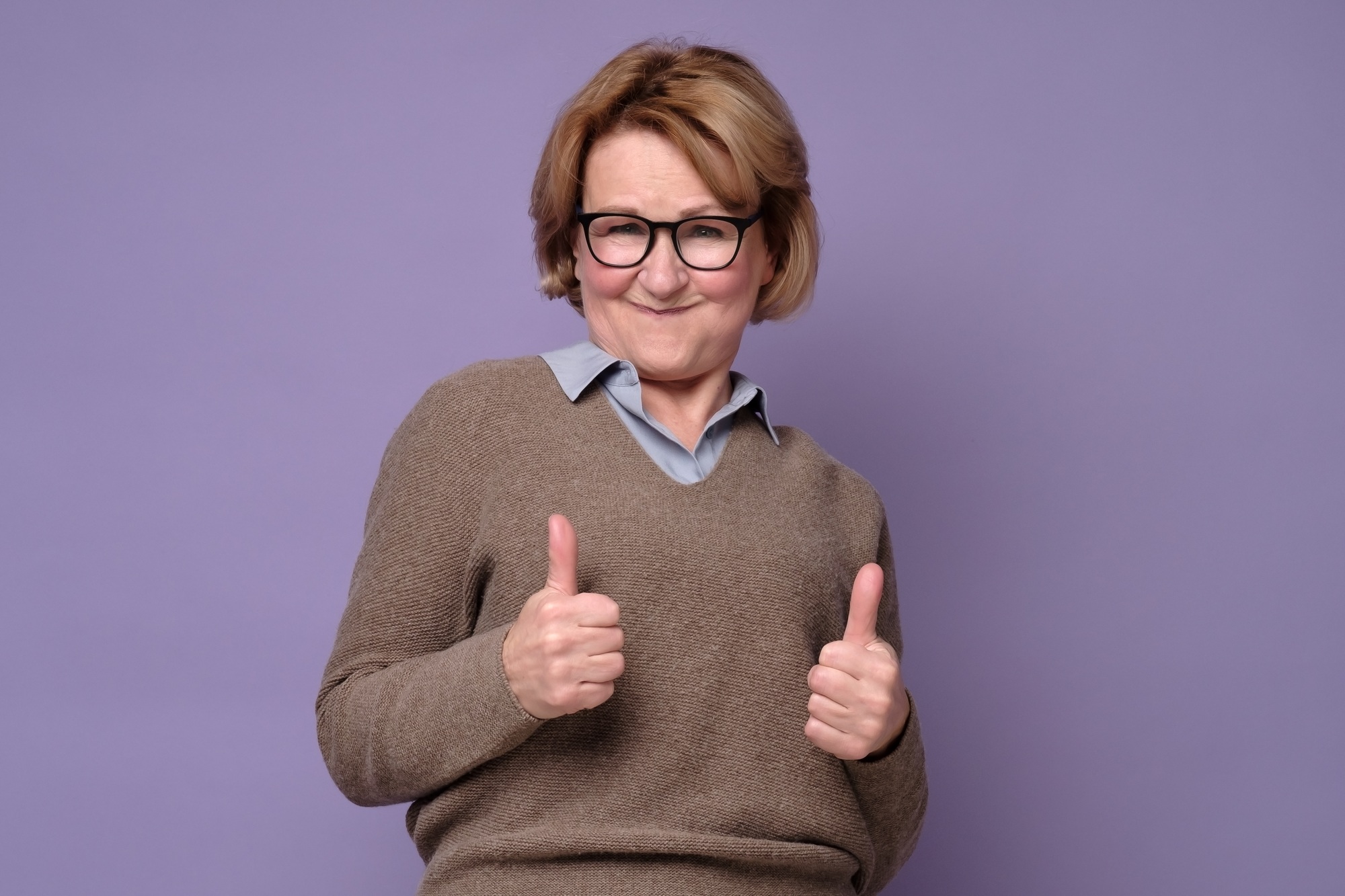 An happy senior woman showing her two thumbs up