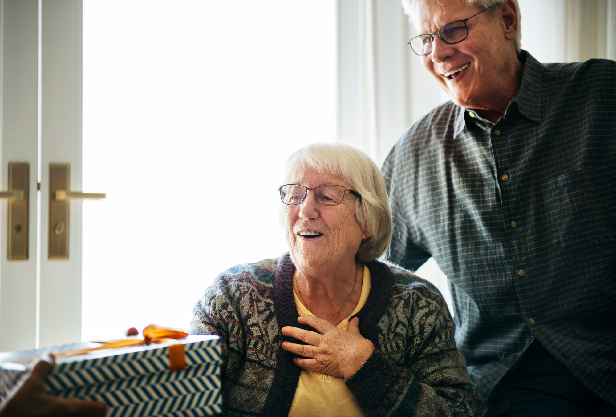Cheerful senior couple receiving a gift box