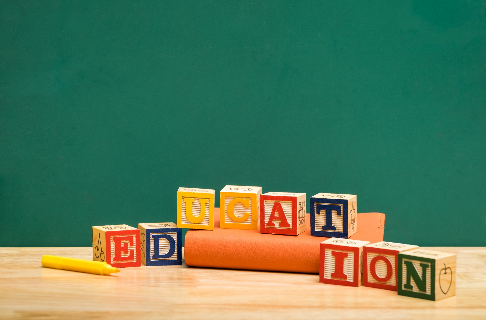 Colorful Education word wood block on orange book