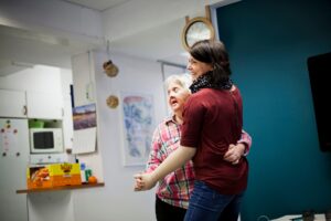 Mentally challenged woman dancing with caregiver at home
