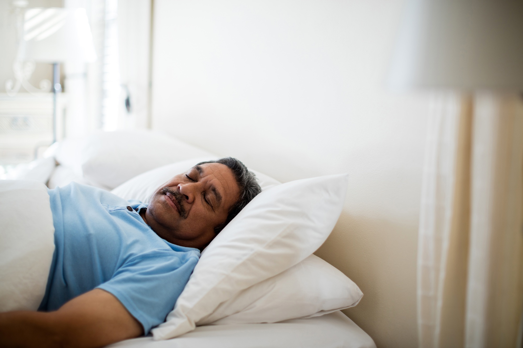 Senior man sleeping in bedroom