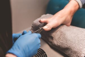 Pedicurist trim nails with manicure clippers