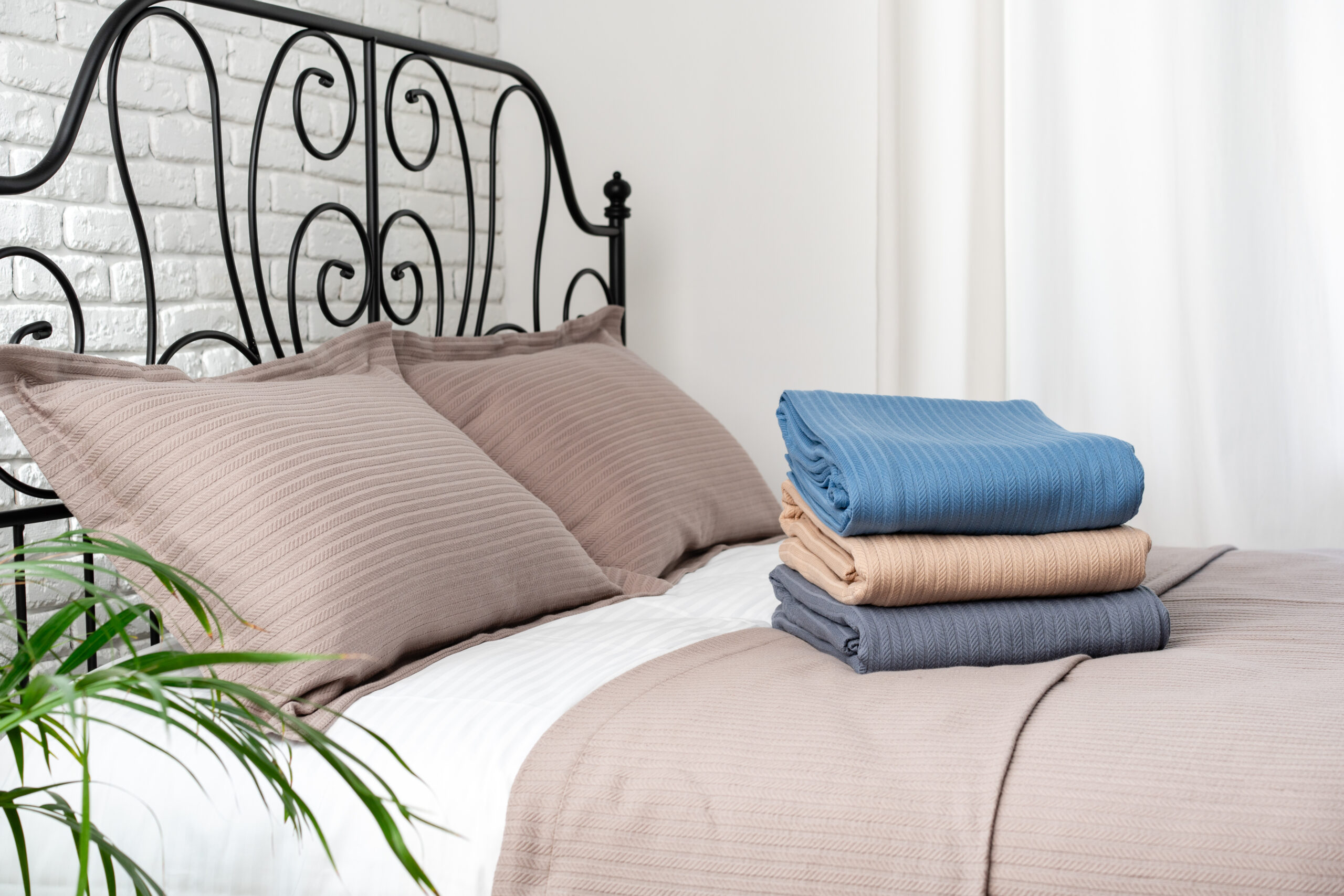 Stacked Blue and Beige Blankets on a Made Bed